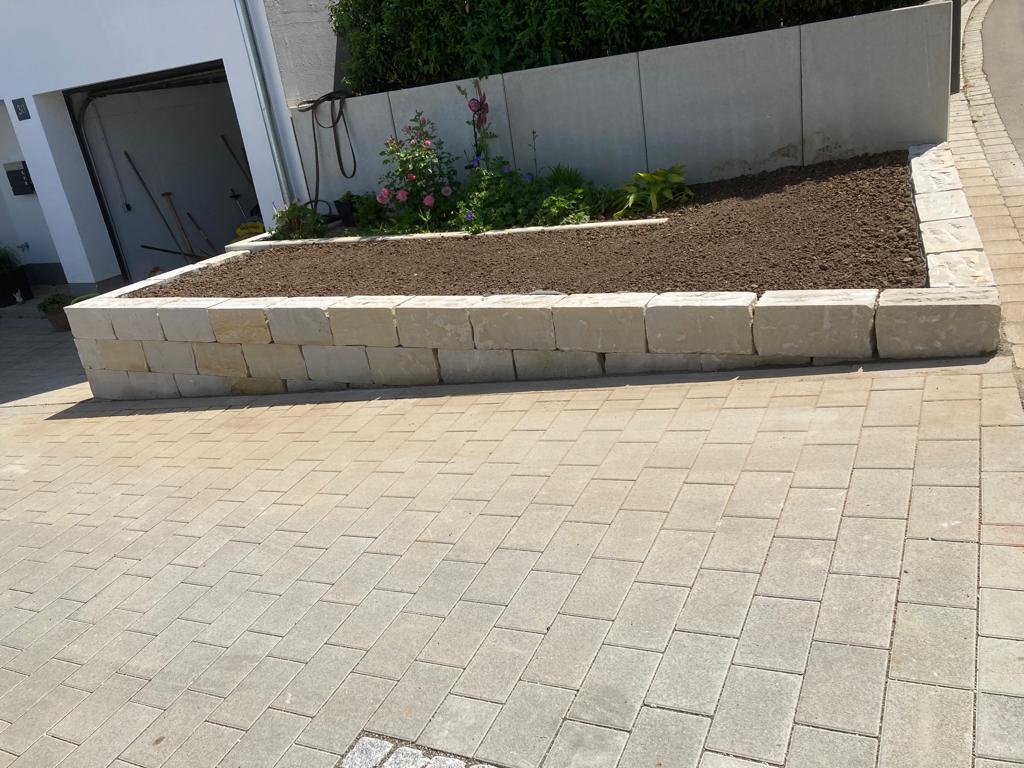 Vorgarten mit Natursteinen und frischer Erde